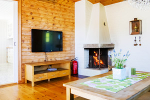 Schweden Ferienhaus am See mit offenem Kamin im Wohnzimmer und deutschem Fernsehen.